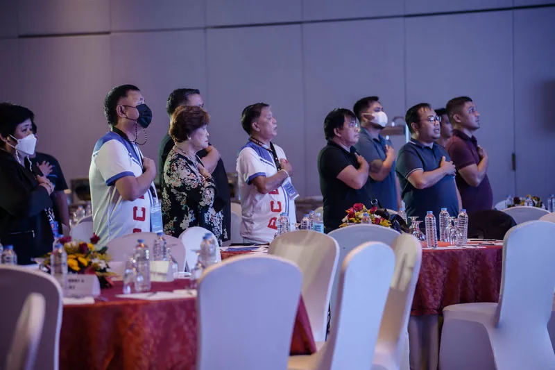 Participants standing during the opening of an orientation programme in a banquet hall